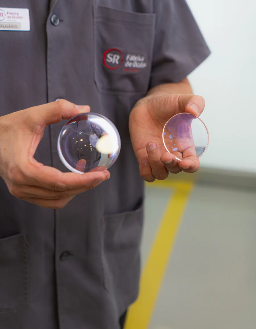 Colaborador da SR Fábrica de Óculos segurando lentes produzidas no laboratório